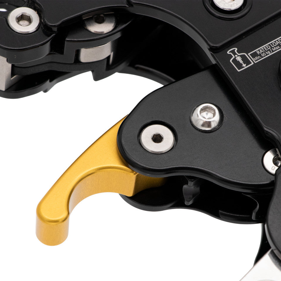 Close-up of a mechanical lever with gold and black components on a white background