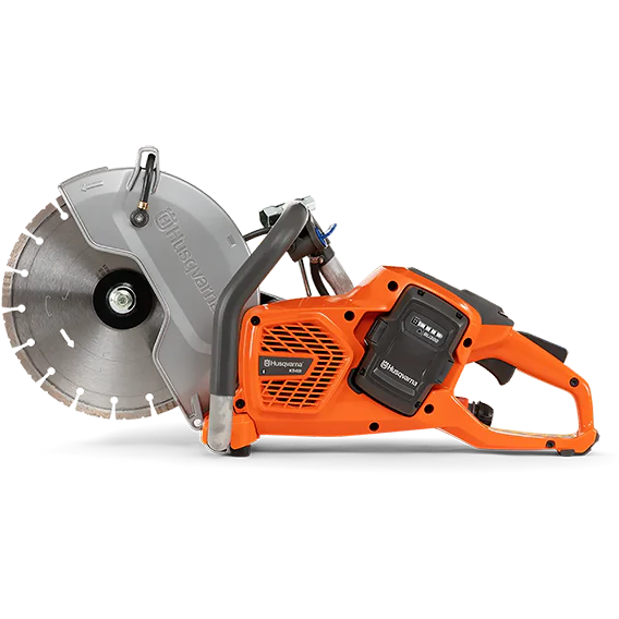 Husqvarna cordless diamond saw with a gray circular saw blade, bright orange body, and black battery pack on a white background.
