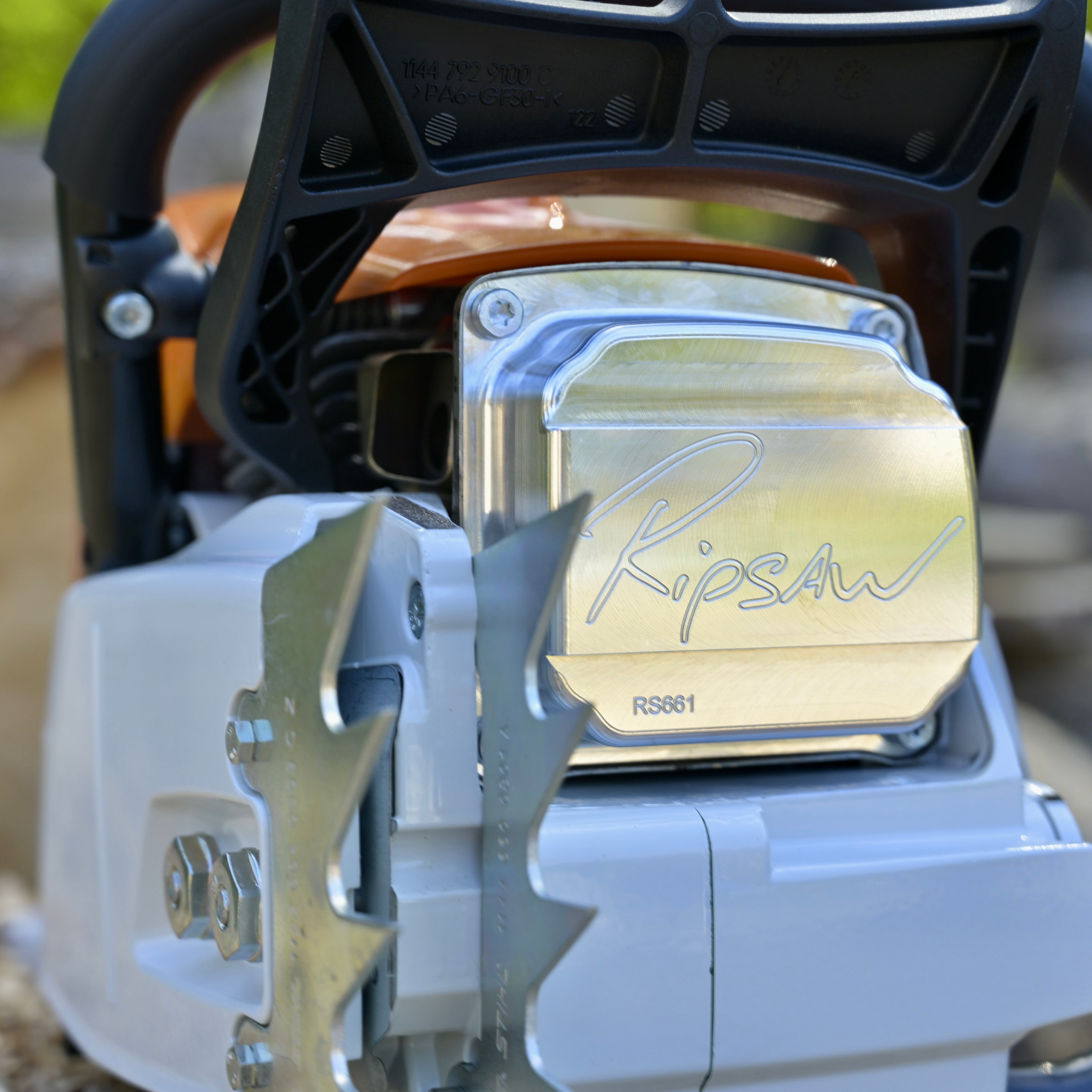 Close-up of a chainsaw with 'Ripsaw' branding on a blurred natural background