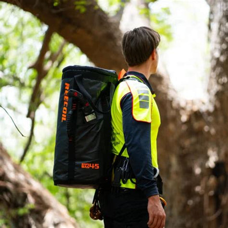 Person wearing a high-visibility vest and carrying a Reecoil Rope Bags - 45 Liter