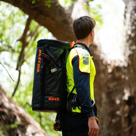 Person wearing a high-visibility vest and carrying a Reecoil Rope Bags - 45 Liter